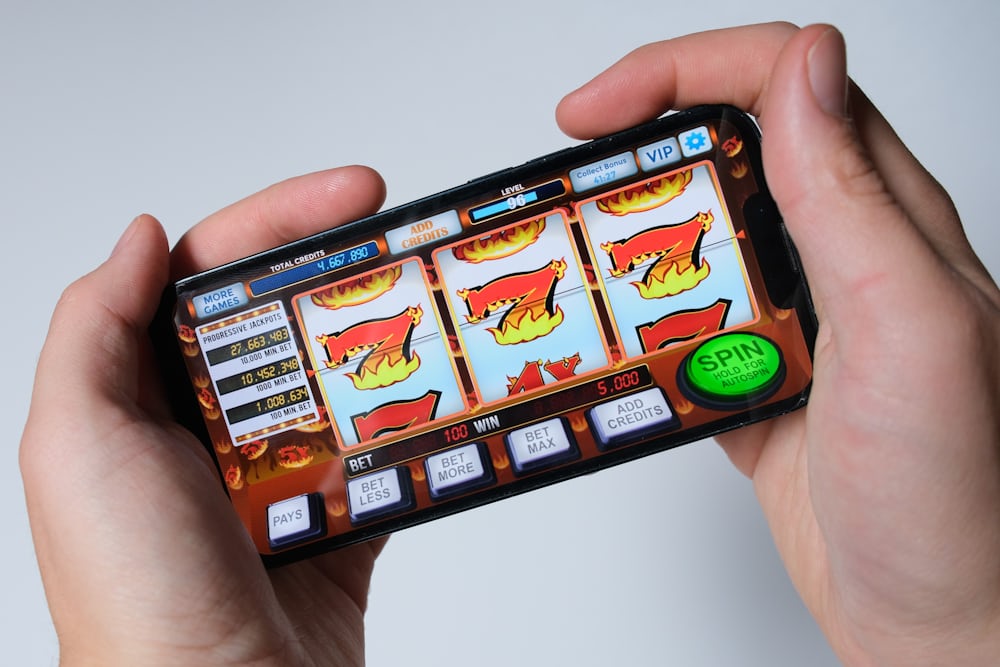 Seseorang bermain game slot di ponsel — ilustrasi pengalaman seluler